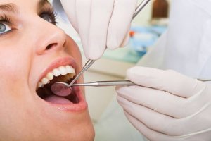 uma mulher pergunta como fortalecer os dentes soltos durante o seu exame